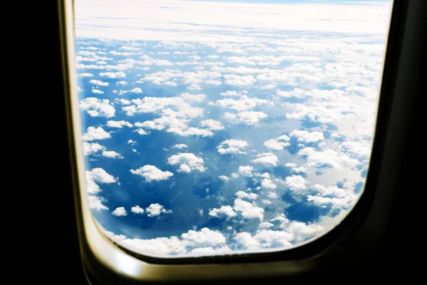 Fluffy bílé mraky a modré nebe vidět z letadla. — Stock fotografie
