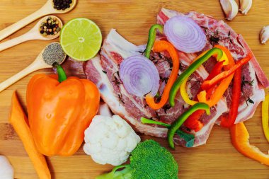 Barbekü için çiğ et parçaları üzerinde ahşap yüzey, menü yemek tarifleri dilimlenmiş. Gıda, biftek, biftek Barbekü, domates, biber, baharat   .