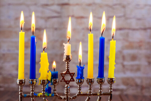 Menorah with candles for Hanukkah against defocused lights