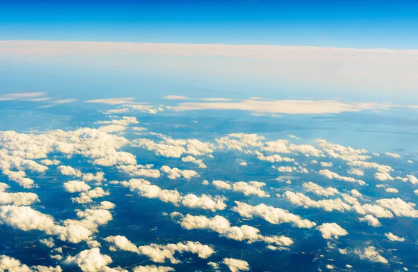 Nuvens brancas fofas e céu azul visto do avião. — Fotografia de Stock