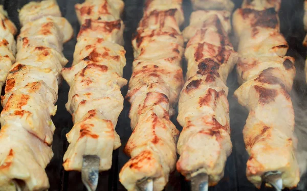 Gegrilde shish kebab op metalen Spies. De handen van de chef-kok koken geroosterde vlees barbecue met veel rook. — Stockfoto