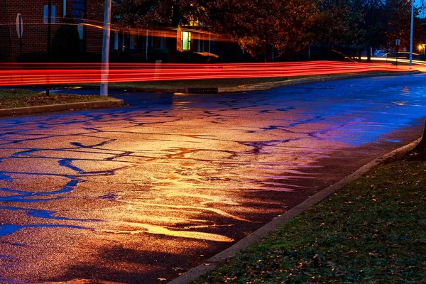 Regnerische Nacht in der Großstadt, Licht aus den Schaufenstern spiegelt sich auf der Straße — Stockfoto