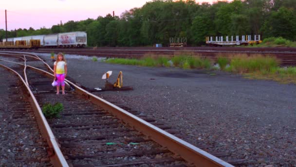 Menina corre ao longo da estrada de ferro — Vídeo de Stock