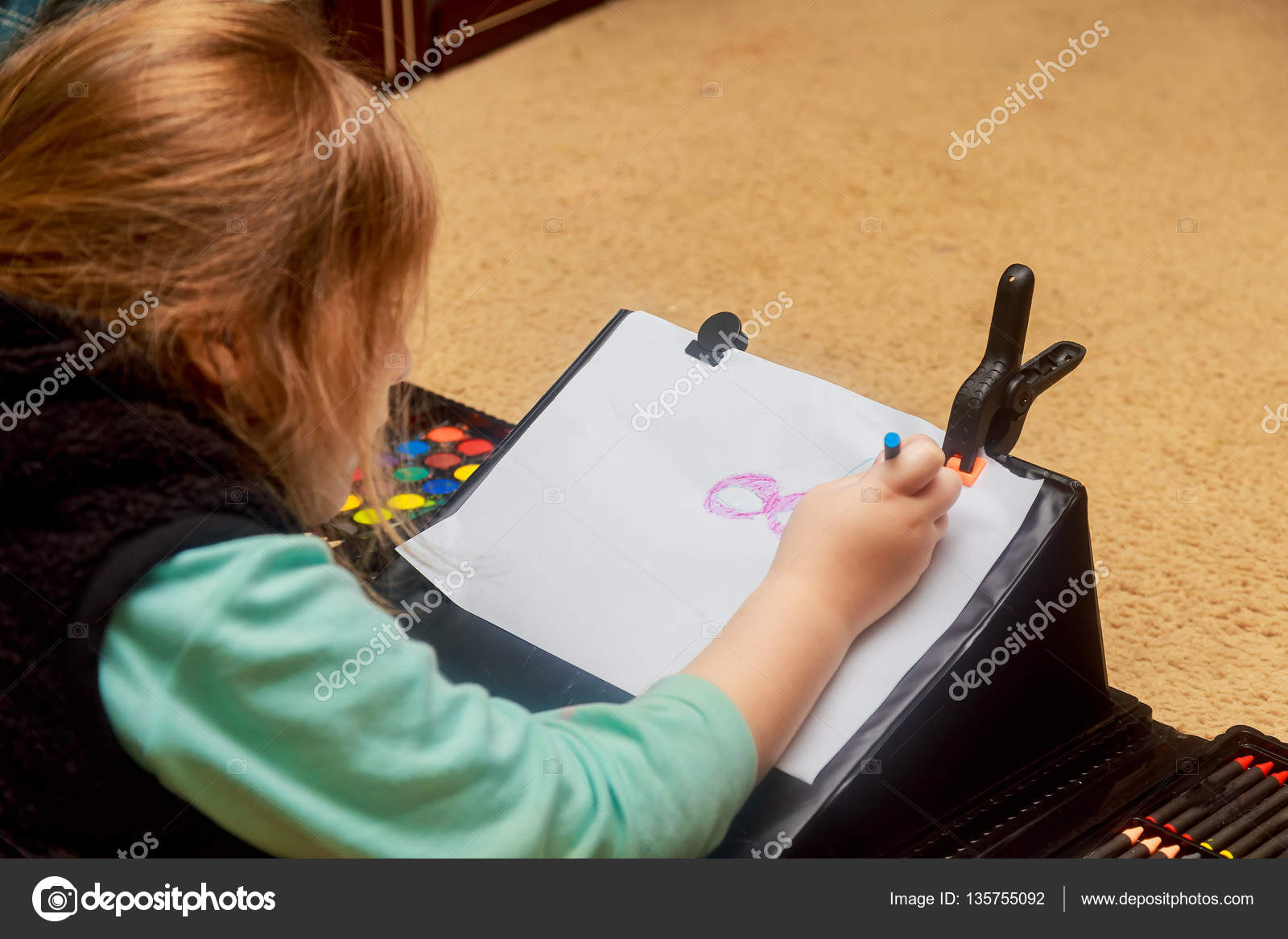 Bambina ¨ il disegno con matite colorate mentre posa sul pavimento — Foto Stock