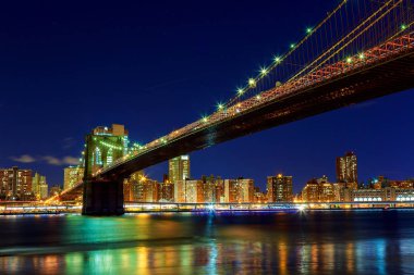 Brooklyn Köprüsü'nün gece New York'ta Manhattan'ın Doğu Nehri üzerinde