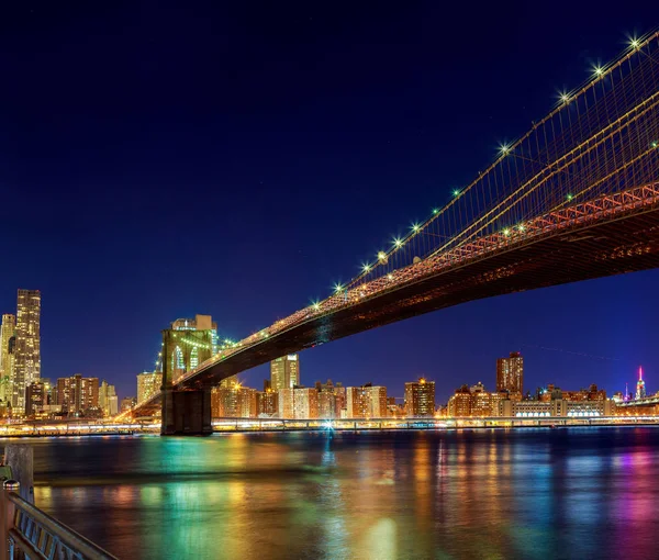 New York City Manhattan Bridge nad rzeką Hudson z skyline po zachodzie słońca nocy Zobacz podświetlany l — Zdjęcie stockowe