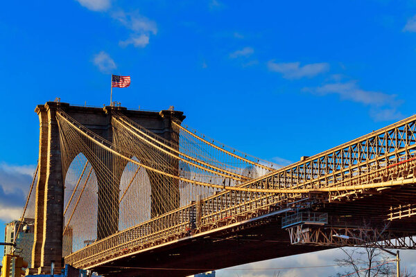 American flag on Brooklyn Bridge Brooklyn bridge with cloudy blue sky, New York
