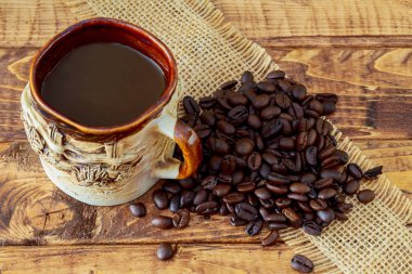 Coffee cup and beans on wooden table background