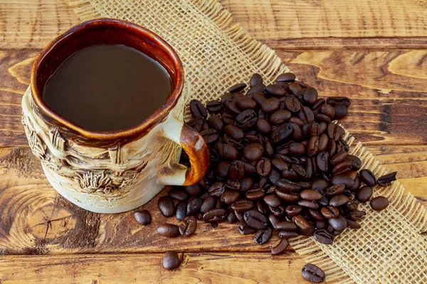 Coffee cup and beans on wooden table background