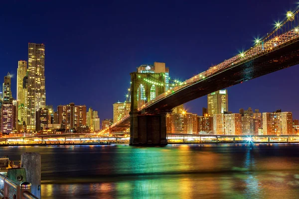 Brooklynský most za soumraku při pohledu z parku v New York City. — Stock fotografie