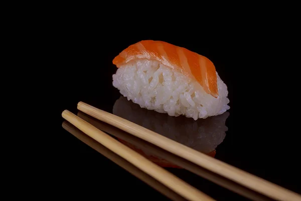 Classic sushi with salmon over black background — Stock Photo, Image