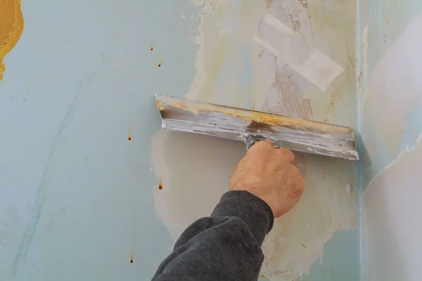 Мастер делает ремонт квартиры и облицовка стен шпаклевкой — стоковое фото