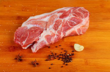 Üstten Görünüm çiğ domuz eti biftek ve sarımsak, biber ahşap arka plan.