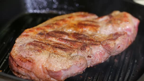 Bifes de carne grelhada quente estão cozinhando na panela de grelha — Vídeo de Stock