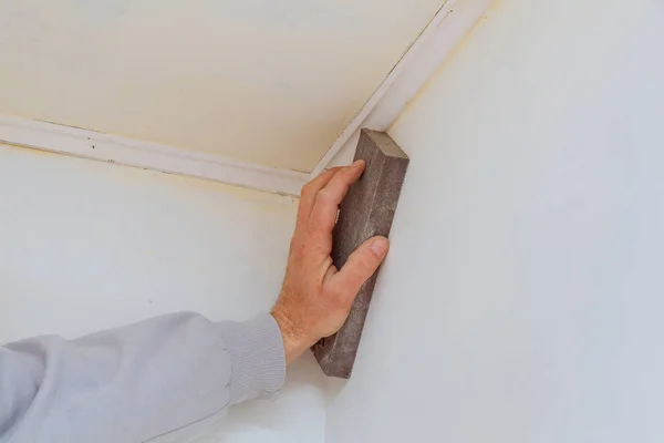 Reparación de la habitación, lijar a mano la pared con una esponja de lijar — Foto de Stock