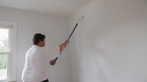 Acercamiento del trabajador profesional que sostiene el rodillo sucio de la pintura — Vídeo de stock