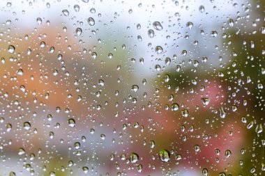 Mavi camlı arka planda yağmur damlaları. Sokak Bokeh Işıkları Odaksız.