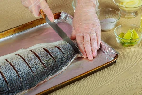 Vrouw rauwe vis op keuken koken — Stockfoto