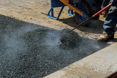 Erkekler kürek ile yol asfaltlama üzerinde çalışma zor