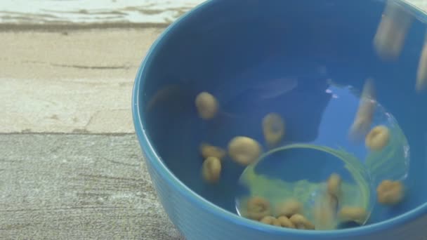 FECHAR UP: cereais integrais caindo em tigela para o café da manhã — Vídeo de Stock