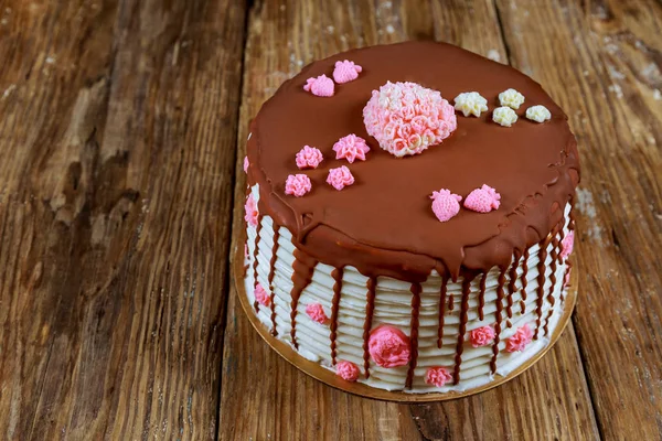 Pastel cubierto de chocolate con rosas rosadas el tablero viejo — Foto de Stock