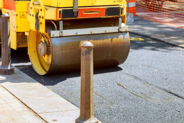 Kentsel yol yapım aşamasında olduğunu sarı silindir asfaltlama