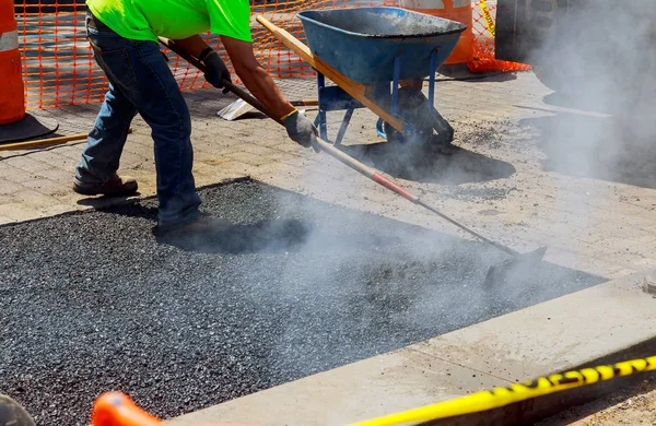 Hombres en el trabajo, camino urbano en construcción, asfalto en progreso — Foto de Stock