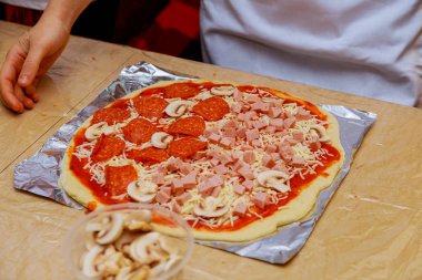 Erkek hazırlanıyor hamur pizza üzerinde tablo closeup için eller