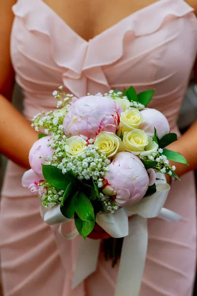 Jonge Kaukasische vrouw in roze kant jurk houdt een boeket — Stockfoto