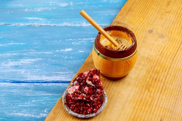 Stücke reifen Granatapfel auf einem Weidenteller Nahaufnahme blauen Holz Hintergrund — Stockfoto