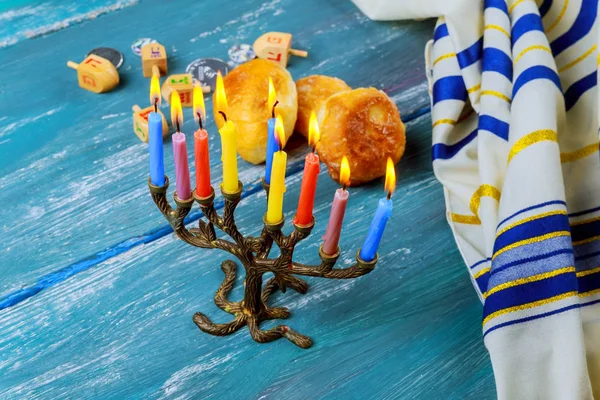 Menora z świece i słodkie pączki są tradycyjne żydowskie symbole — Zdjęcie stockowe