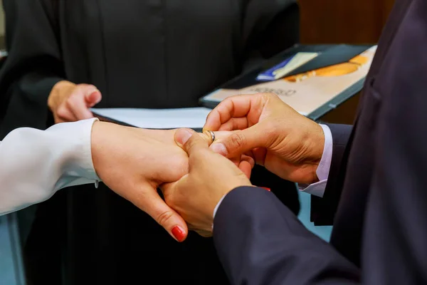 Beauty bride and handsome groom are wearing rings each other. — Stock Photo, Image