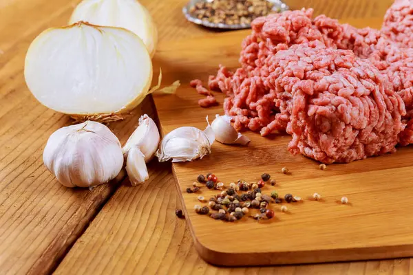 Minced meat in butcher paper with onion garlic — Stock Photo, Image