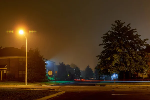 Rastreo de coche en un camino nocturno vacío en una niebla —  Fotos de Stock