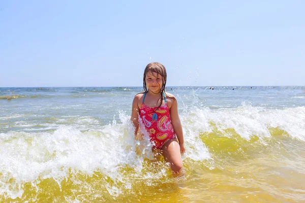 Menina feliz em um oceano de praia tropical se diverte com splash — Fotografia de Stock