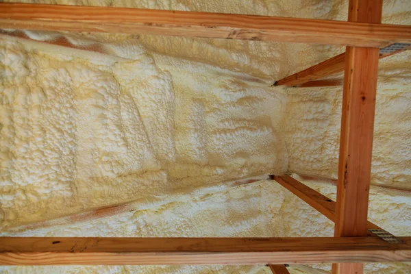 Plastové izolační pěny v šikmým stropem nového rámu domu. — Stock fotografie