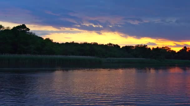 Bir göl kenarında bir gün batımı, kırmızı ve pembe bulutlu gökyüzü doğa manzara — Stok video
