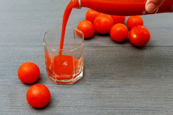 Suco de tomate acabado de fazer em um jarro de vidro placa de madeira . — Fotografia de Stock