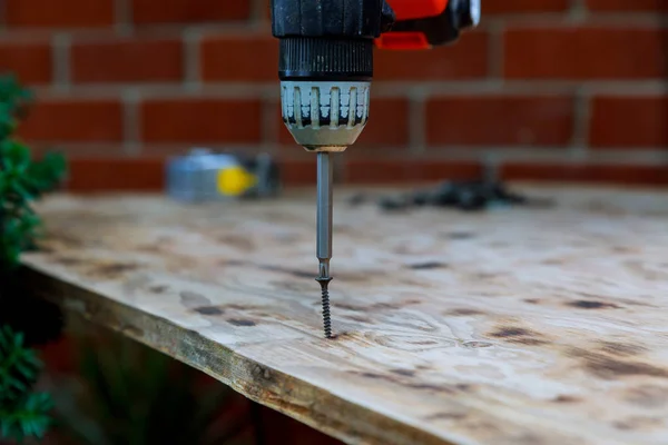 Instalación de tornillo de torsión de madera del trabajador en el tablero de madera . — Foto de Stock