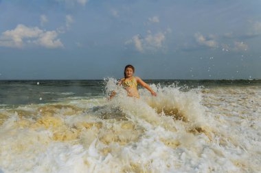Yeşil mavi okyanusta yüzen bir surboard üzerinde gün batımını izlemek bir sörfçü kız güneş patlaması ile yaktı