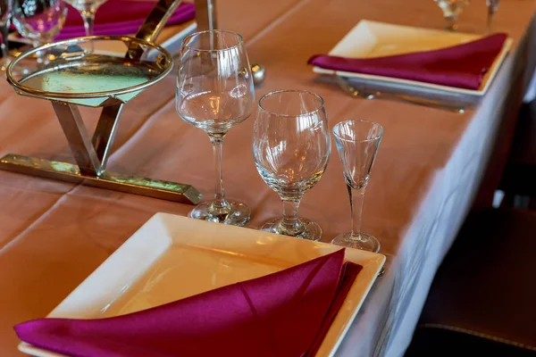 Vasos, flores, tenedor, cuchillo servido para la cena en el restaurante con acogedor —  Fotos de Stock