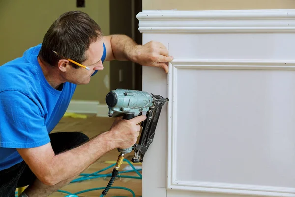 Timmerman met behulp van een brad nagel pistool Voltooi framing trim — Stockfoto