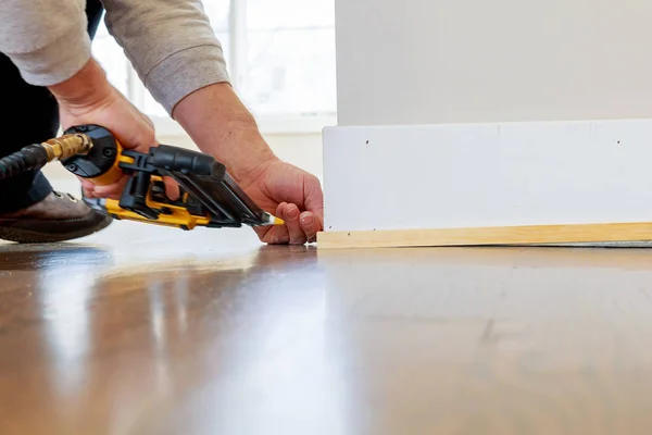 Gauge Finish Nailer man nailed slats custom house molding contractor up a wall section for luxury — Stock Photo, Image