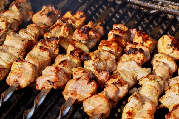 Marinated shashlik preparing on a barbecue grill over charcoal. Shashlik or Shish kebab — Stock Photo, Image