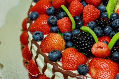 kadife kek güzel çilek çilek, ahududu, yaban mersini ve nane gümüş kağıt üzerinde yalan