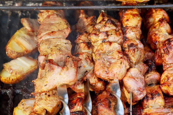 Dym unosi się nad smażone mięso na szaszłyki na węgielkach. — Zdjęcie stockowe
