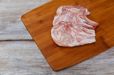 Ahşap kesme tahtası üzerinde çiğ domuz eti biftek