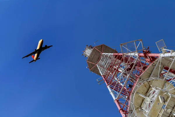 Telecommunications tower against blue sky, in red and white — Stock Photo, Image