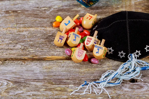 Image of jewish holiday Hanukkah with wooden dreidel spinning top on the glitter background