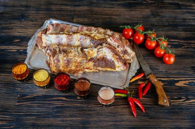 Çiğ çiğ Domuz kaburga üzerinde ahşap kesme tahtası siyah dokulu arka plan pişirmeye hazır.